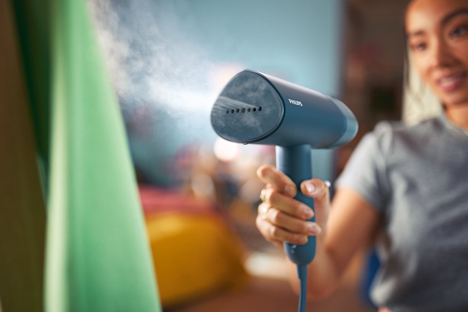 Steam emerging out of blue Philips clothes steamer.
